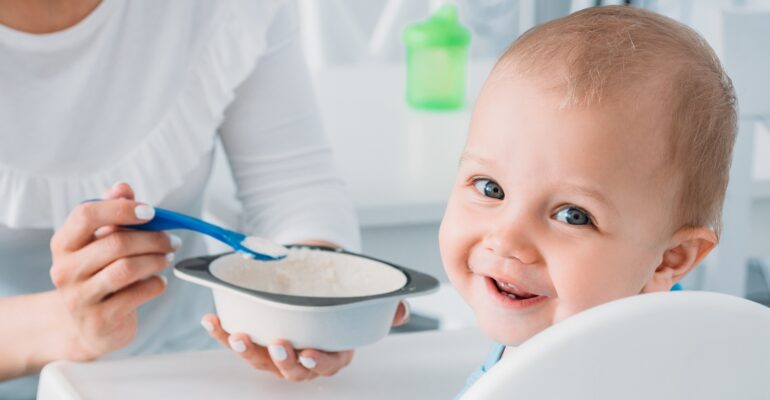 A mother feeding her baby with healthy food for a 9-month-old